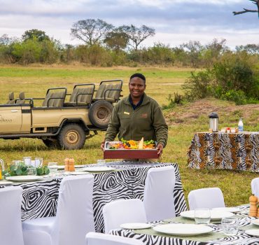 Outdoor breakfast setup at Arathusa Safari Lodge with staff