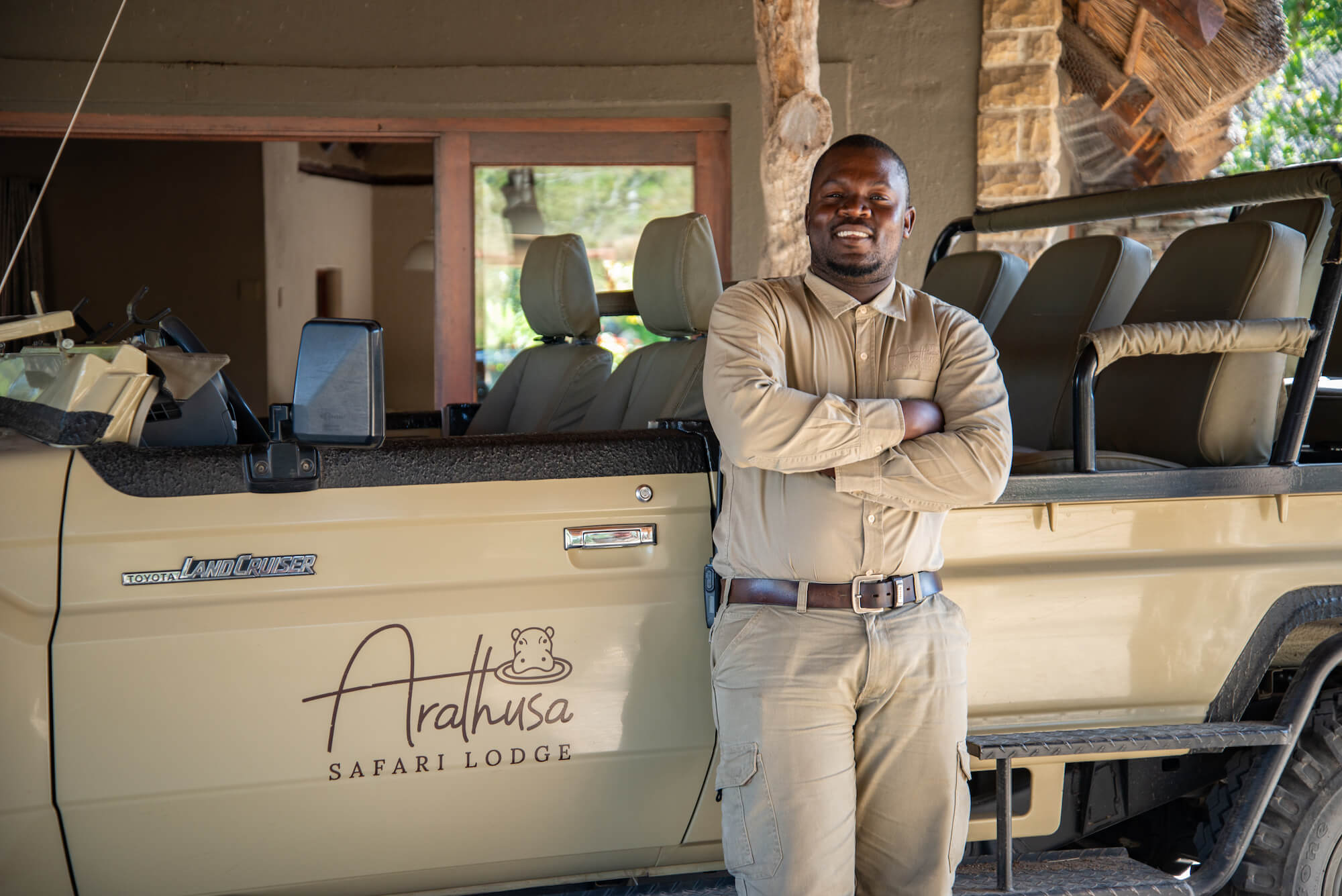 black-man-standing-next-to-a-brown-safari-vehicle